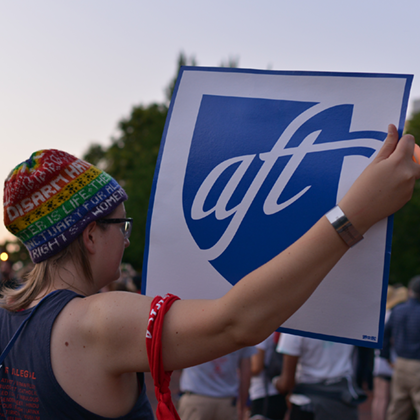 Photo of protestor holding up AFT sign