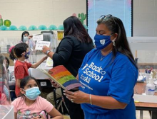 Photo of AFT Executive Vice President Evelyn DeJesus reading a book to students